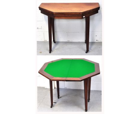 An early 20th century oak octagonal fold over card table, on tapering square section supports terminating in castors, length 