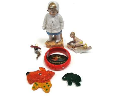 A c.1930s Art Deco collection of 2 ceramic figures, a red bakelite bracelet decorated with Pierrot, an elephant brooch, dog w