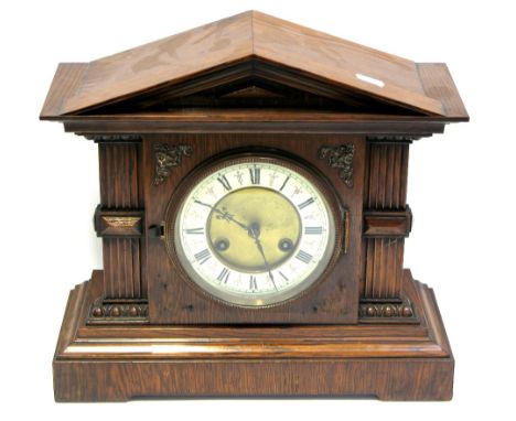 An early 20th century oak case mantel clock, enamel and gilded dial set with Roman numerals, height 34cm.