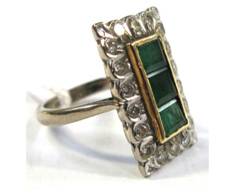 An 18ct white gold Art Deco ring of rectangular form with three central rectangular emeralds and diamond surround, approx wei