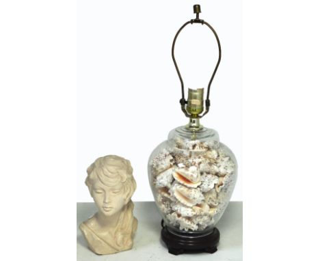 A glass baluster form table lamp filled with various shells, height 30cm and a small French plaster bust of Brigitte Bardot (