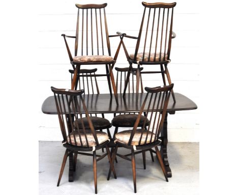 An Ercol dining suite comprising dark oak table and six matching stick back chairs (4+2), length of table 153cm (7). 