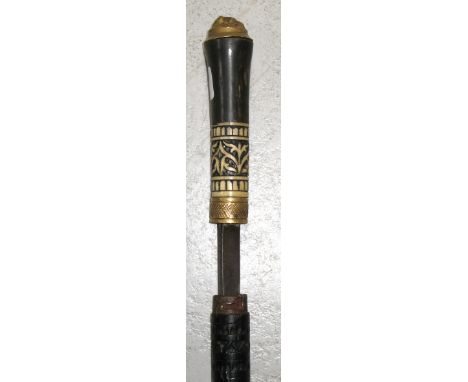 A late 19th century ebonised sword stick with carved ivory decoration to the handle and a yellow metal collar.