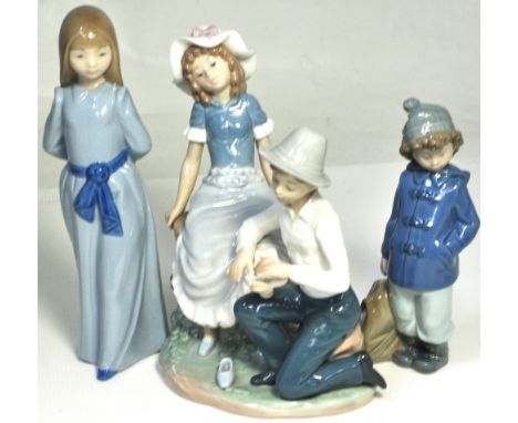 Three Nao figurines; a boy putting a bandage on a girl's foot, a young girl in costume and a young boy holding a bag (3).