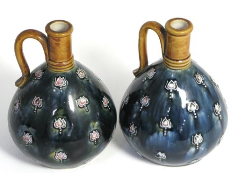 A pair of Art Nouveau Royal Doulton jugs, initialled to the underside "M.B" for Maude Bowden, height of each 17cm.