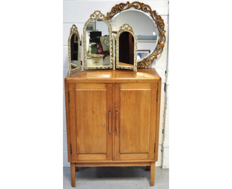 An Art Deco style oak two door cupboard on legs, 99 x 76cm, a small triple mirror and a round mirror (3).