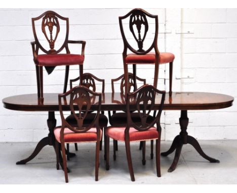 A reproduction mahogany extending dining table on two tripod supports with single extending leaf, length when extended approx