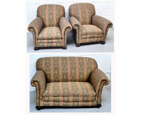 An early 20th century three piece lounge suite comprising a two seat sofa and two arm chairs upholstered in green and gold, l