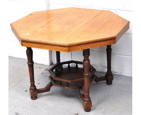 An early 20th century oak octagonal occasional table with lower shelf and raised on ring turned supports, width 84cm. 