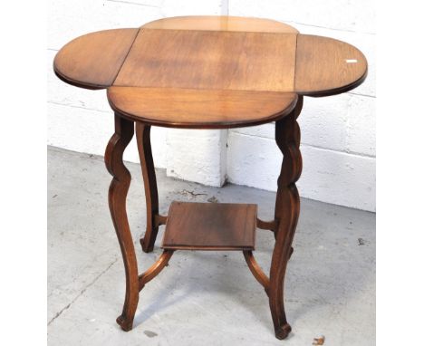 A 20th century oak drop leaf occasional table with lower shelf and raised on incised outswept supports, height 68cm.