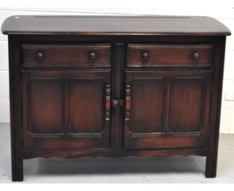 An Ercol style oak sideboard, two short draws above lower twin door cupboard sections, width 120cm. 