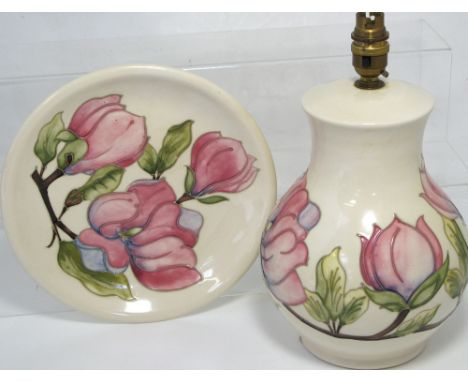 A contemporary Moorcroft cream ground Magnolia pattern lamp, height 31cm, together with a matching plate, diameter 25cm (2).