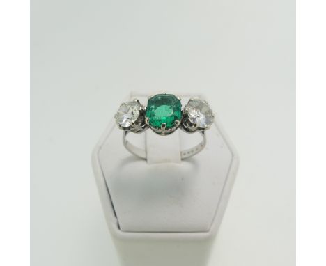 An emerald and diamond three stone Ring, the central octagonal step cut emerald, approx 1.2ct, with a brilliant cut diamond o