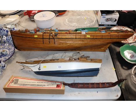 A wooden model of a barge, a model of a sailing ship and a model of a war canoe