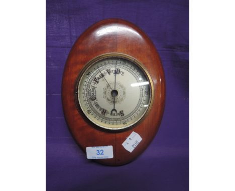 A vintage barometer with wooden surround