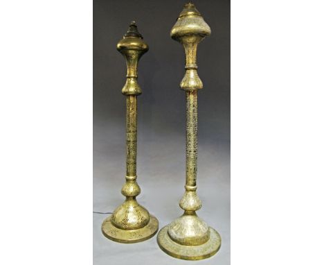 A matched pair of Middle Eastern brass lamp stands, late 19th/20th century, both with pierced bodies, decorated with panels o