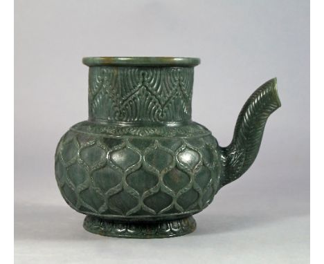 A jade style wine ewer or aftaba in the Mughal taste, carved to the neck with ogee arches above stiff leaf collar, with wavy 