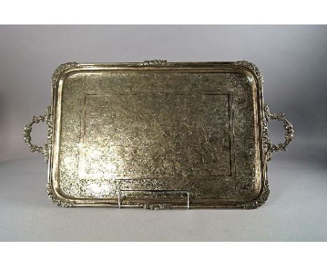 A Persian rectangular white metal tray, late 19th/early 20th century, with twin handles and shaped corners, engraved to the c