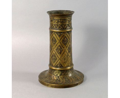A Safavid brass candlestick, circa 1600, of faceted cylindrical form, with engraved panels, 21.5 cm high.  CONDITION REPORT: 
