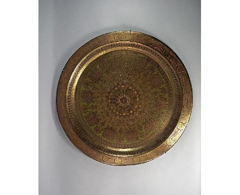 An Islamic brass tray, late 19th century, engraved with concentric bands of floral decoration, with conforming decoration to 