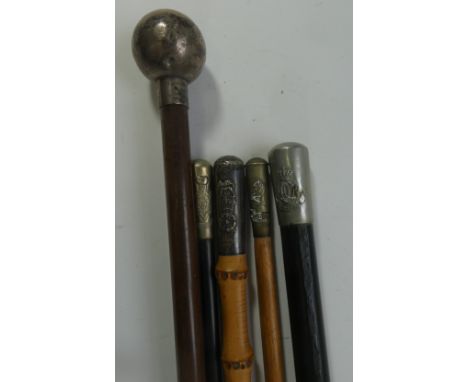 A COLLECTION OF MILITARY SWAGGER-STICKS, comprising approximately 18 narrow canes with white metal caps of regiments and othe