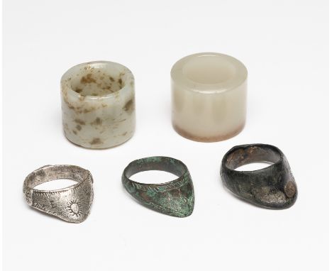 ELEVEN ARCHERS RINGS, 18TH CENTURY AND LATER, the first Chinese, of white jade with a darker base; the second Chinese, of mot