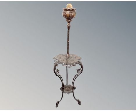 An antique ornate cast iron rise and fall oil lamp table 