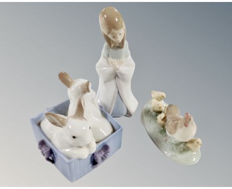 A Lladro figure  of a girl in shawl kneeling, together with two Nao figures  'Hen with chicks' and 'Two rabbits'