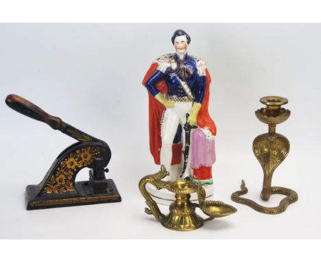 An Indian brass candlestick in the form of a cobra, a brass chamberstick, Staffordshire figure of Prince Albert A/F, and an e