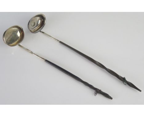 A Georgian silver toddy ladle, the oval bowl with inset coin on a baleen spiral twist handle 37cm long together with another 