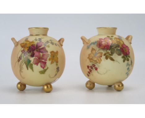 A pair of Royal Worcester blush ivory miniature vases, of ovoid form, with loop handles to the sides painted floral decoratio