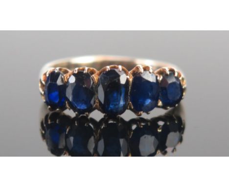 A Graduated Sapphire Five Stone Ring in a precious yellow metal setting, c. 6.6x4.5mm principal stone, size O.5, KEE tests as