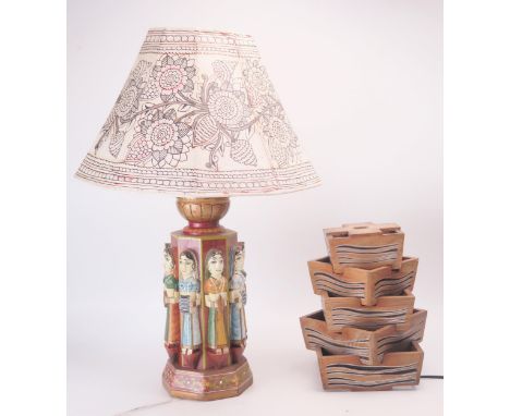 An Indian carved hardwood and polychrome decorated table lamp. of octagonal outline decorated with female figures. on a flora