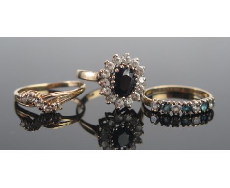 A 9ct Gold, Sapphire and CZ Cluster Ring (size N), 9ct gold crossover ring (size L) and one other (size L), all hallmarked, 5