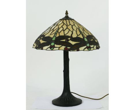 A Tiffany style table lamp in the Art Nouveau style, the domed shade decorated with dragonflies, on a naturalistic stem and c