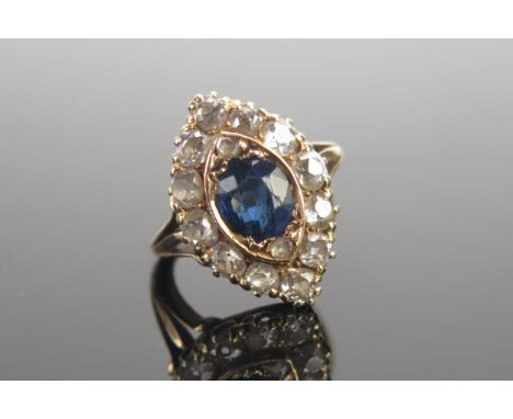 An 18ct Gold, Sapphire and Diamond Marquis Ring, c. 7.4x6.5mm principal stone, surrounded by twelve c. 3mm old cuts, 21.4x14.