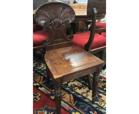 A George IV rosewood hall chair in the manner of Gillows, the carved shell and scrollwork back over a panel seat and reeded a