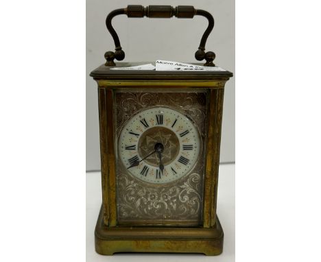 A circa 1900 French lacquered brass cased carriage clock, the engraved silvered dial with porcelain chapter ring and Roman nu