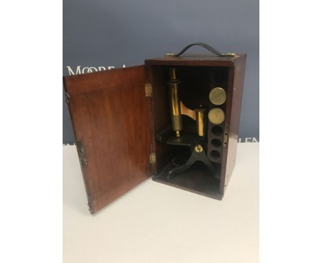 An early 20th Century brass microscope housed in mahogany case 17.5 cm wide x 15.5 cm deep x 29.5 cm high, the microscope sta