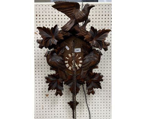 A modern Black Forest type cuckoo clock of typical form decorated with birds amongst foliage, 37.5 cm wide x 68 cm high