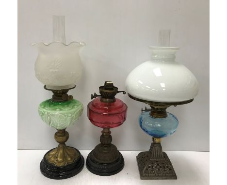 A collection of five various Victorian and later oil table lamps, one with faceted ruby glass reservoir, one with pale blue r