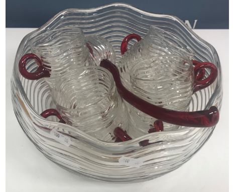 A late 20th Century punch bowl, glasses and ladle with wavy decoration and red glass handles