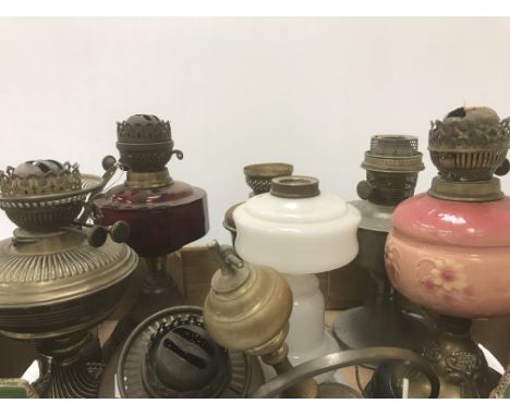 Nine various Victorian and later oil lamps, a milk glass oil lamp base, copper oil lamp reservoir and a brass lamp base (vari