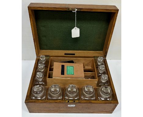 An oak cased medicine chest for "Davies &amp; Shepheard Chemists 12 Bridge Street Row Chester", containing eleven clear glass