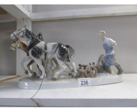 A pair of ceramic horses pulling a plough