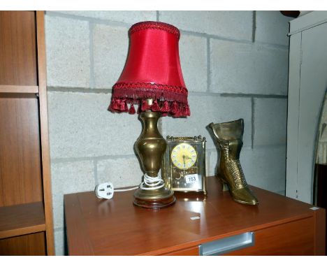 A clock, a table lamp and a brass boot