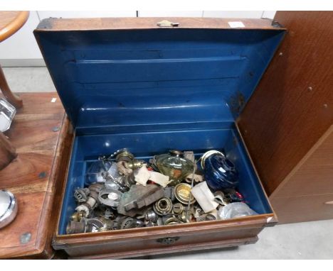 A large quantity of oil lamp parts in a tin trunk