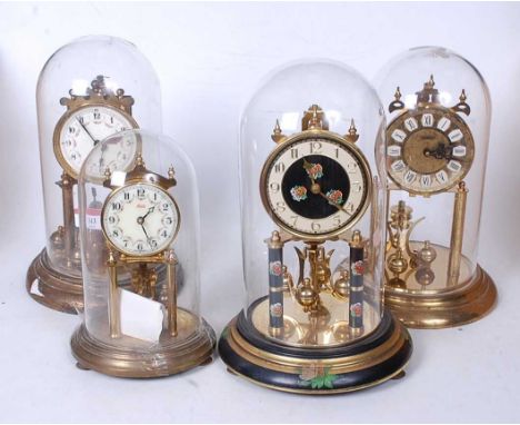 A Kundo lacquered brass anniversary clock, having a circular enamel dial with Arabic numerals under a glass dome, together wi