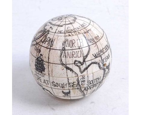 A reproduction faux ivory model of a pocket globe, opening to reveal a compass