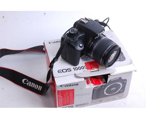 A Canon EOS 1000D digital camera, boxed, with charger, battery, and instructions